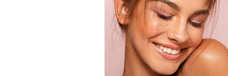Close-up of a woman's face showcasing Nude Beach lip gloss shade with a soft pink background