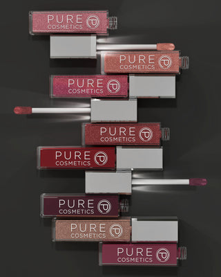 Stack of Pure Cosmetics lip glosses on a dark background