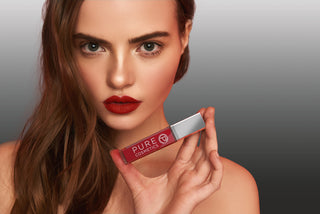 Model holding Pure Cosmetics Light Up Lip Gloss with LED light and mirror, perfect for easy, on-the-go beauty touch-ups.