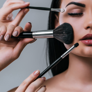 Model applying makeup with Pure Cosmetic brushes, showcasing a professional beauty routine.