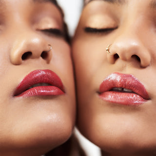 Two models wearing hydrating Light Up Lip Gloss in different shades, highlighting glossy, moisturized lips with a radiant finish. The gloss adds a luminous shine and smooth texture to each model’s lips.
