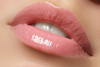 Close-up of glossy pink lips showcasing hydrating lip gloss.
